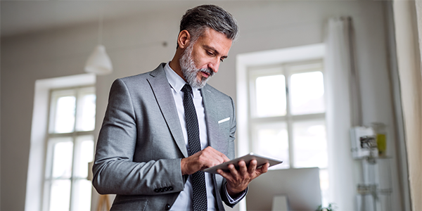 pracownik firmy z tabletem w dłoni aktywującym eFakturę przez internet