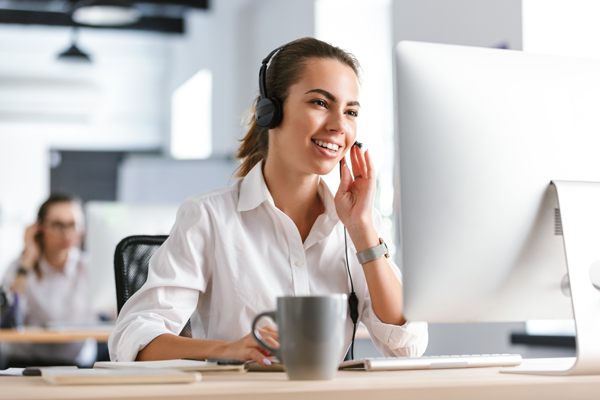 pracownik telefonicznej obsługi klienta przy biurku udziela informacji klientowi