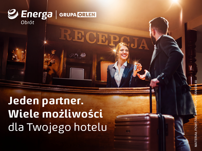 Gość hotelowy odbierający kartę do pokoju przy recepcji.