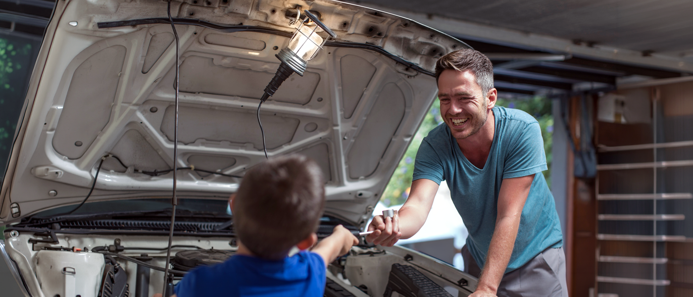 Ojciec z synem naprawiają samochód w garażu