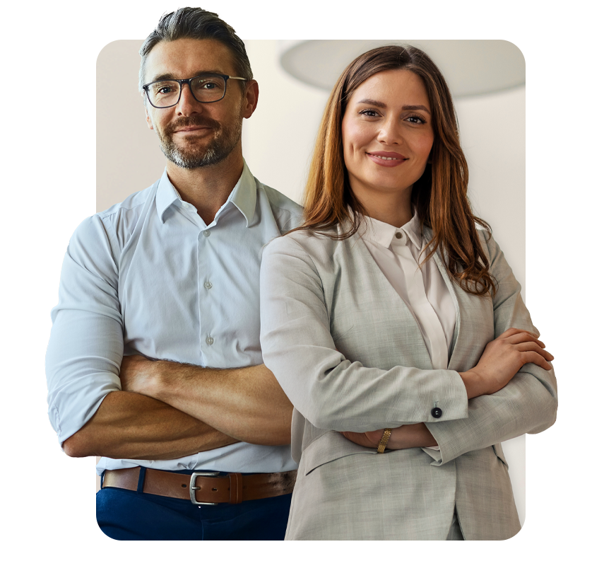 Uśmiechnięta para biznesowa patrząca na wprost z rękami założonymi na ramionach