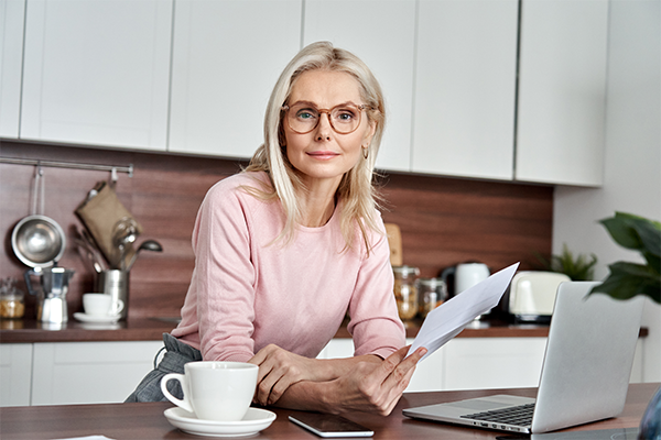 Kobieta w kuchni analizuje swoją fakturę za prąd