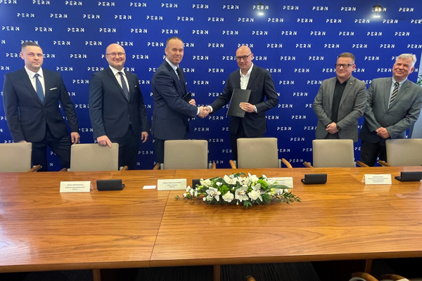 Przedstawiciele firm po podpisaniu umowy, uśmiechają się do zdjęcia